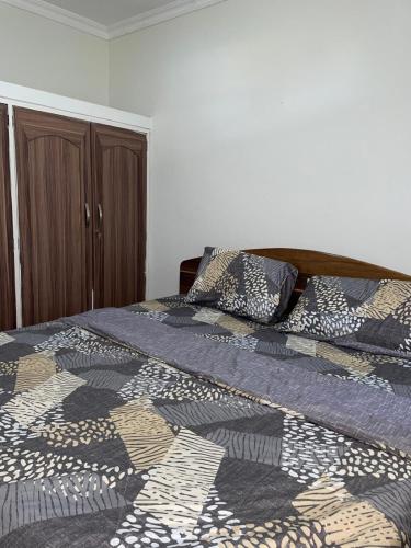 a bedroom with a bed with a comforter on it at Modern 1-Bedroom Apartment with AC & Fast WiFi in Accra