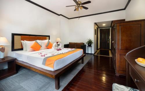 a bedroom with a large bed and a ceiling fan at Le Grande Indochine Hotel in Siem Reap