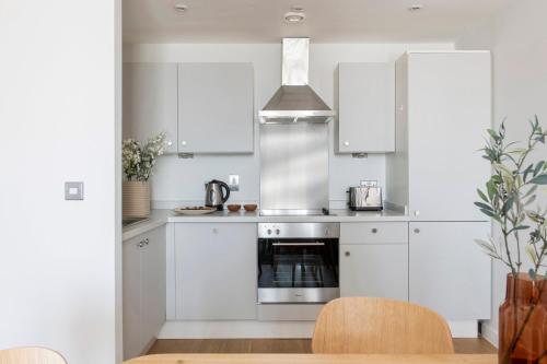 a kitchen with white cabinets and a stove at Cove Paradise Street in Liverpool