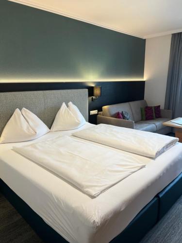 a large white bed in a hotel room at Wander- und Familienhotel Erika in Wagrain