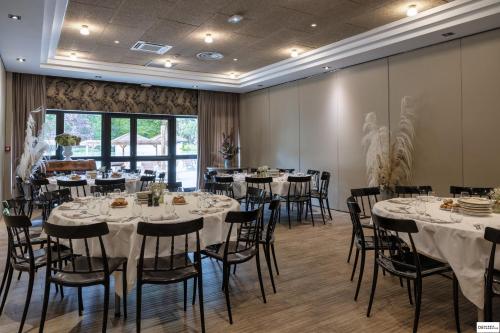 a banquet room with tables and chairs and a window at Hotel Mercure Parc du Coudray - Barbizon in Le Coudray-Montceaux