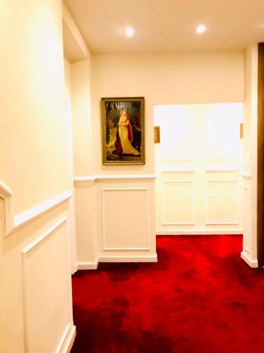 ein Zimmer mit einem Gemälde an der Wand und einem roten Teppich in der Unterkunft Résidence touristique marcadal in Fort de lʼEau