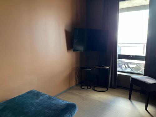 a room with a bed and a tv and a window at Riddertunets utsikt til Slettefjell in Beitostøl