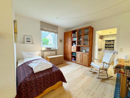 Un dormitorio con una cama y una silla dentro. en Feriennest mit Terasse, en Süderende