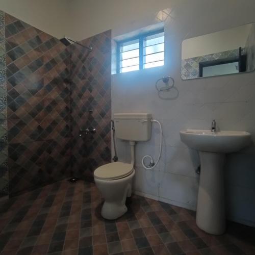 a bathroom with a toilet and a sink at Mad about Coco Yoga & Beach Retreat in Varkala