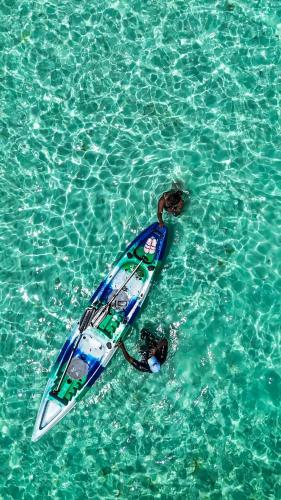 a person laying on a surfboard in the water at Mahi Mahi Beach Hotel in Jambiani