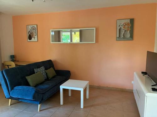 a living room with a blue couch and a table at T2 à deux pas des plages dans le bourg in Le Gosier