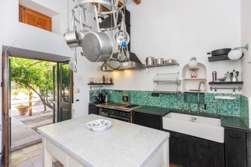 a kitchen with black cabinets and a white counter top at Il Frantoio in Panarea