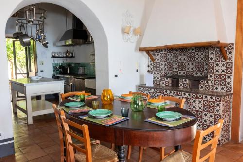 a kitchen and dining room with a wooden table and chairs at Il Frantoio in Panarea