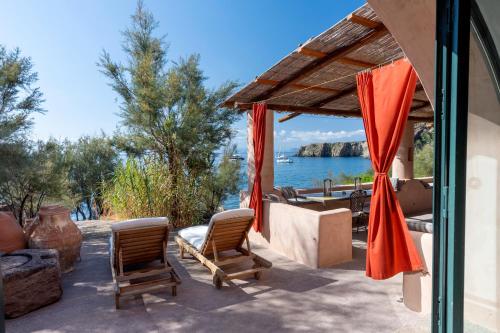 a patio with chairs and a view of the water at Il Frantoio in Panarea
