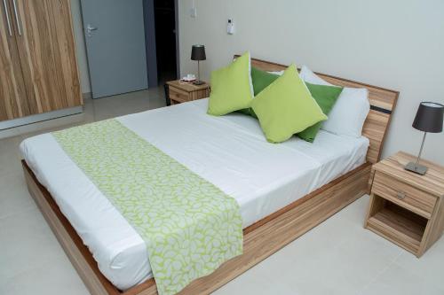 a bedroom with a large bed with green pillows at Casa Florida Hotel & Spa in Pereybere