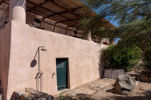 a building with a green door on the side of it at Il Frantoio in Panarea
