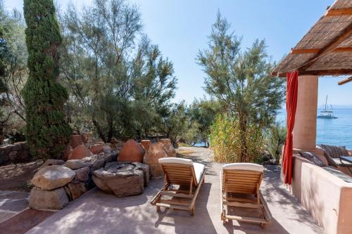a patio with two chairs and a fire pit at Il Frantoio in Panarea