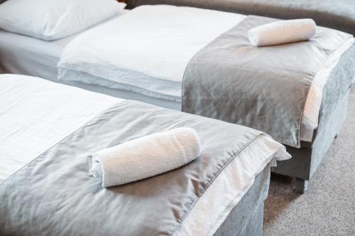 two beds with a towel on the end of them at Dom Wypoczynkowy Elżbieta in Poronin