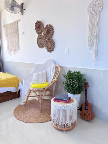 a room with a chair and a table and a guitar at Lantana Homestay in Da Lat