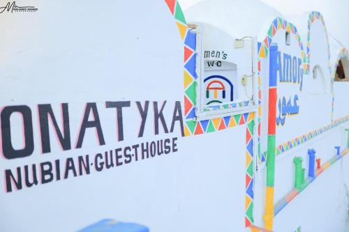 a sign that reads nubian guesthouse and a sign that reads nub at Onaty Ka Guest House in Aswan