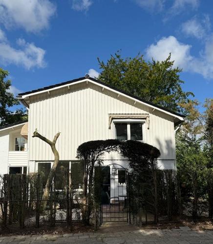 a white house with a fence in front of it at Lekker Tukken in Oldenzaal
