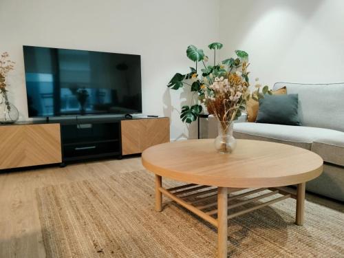 a living room with a coffee table and a tv at Terrazas de Argandona in Gijón