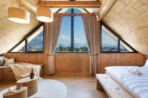 a bedroom with two beds and large windows at Liptovské Chaty in Liptovský Mikuláš