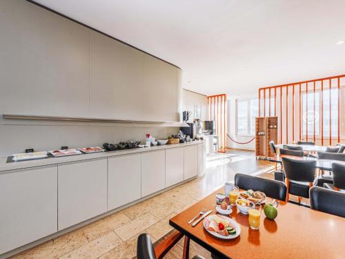 ラシュタットにあるB&B HOTEL Rastattのテーブルと椅子のあるキッチンとリビングルーム