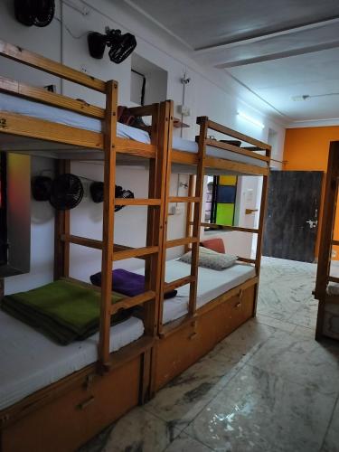 a room with three bunk beds in a room at Moondance Hostel & Garden Restaurant in Pushkar