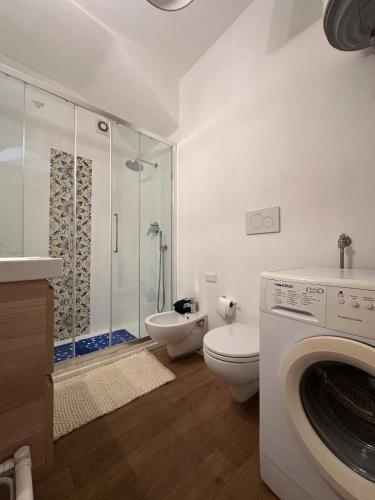 a bathroom with a shower toilet and a washing machine at Casa vista Faraglioni Capri 2 in Capri