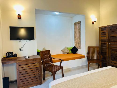 Un dormitorio con una cama, un escritorio y un televisor. en Sekkugala Villa, en Koggala