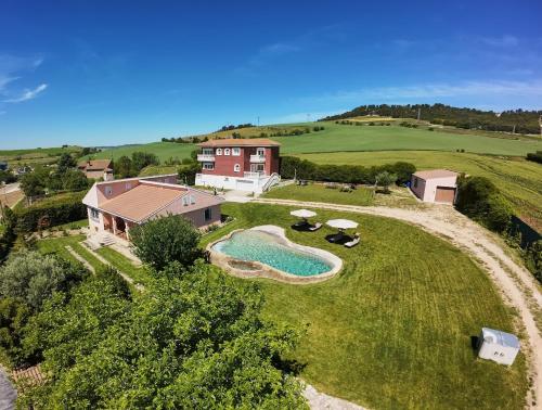 an aerial view of a house with a swimming pool on a grass field at Finca SOTOMAR-casa rural Simancas in Simancas