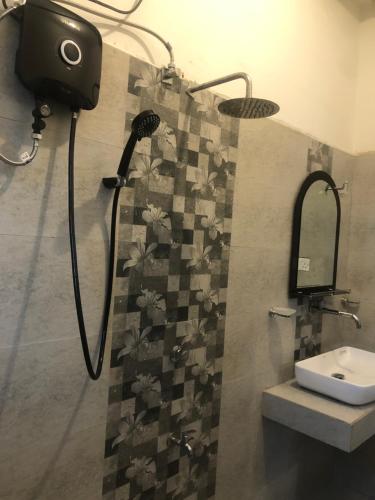 a bathroom with a shower with a mirror and a sink at Hiri Top Homestay in Dickwella