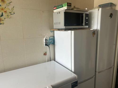 a white refrigerator with a microwave on top of it at Mistral Bobigny in Bobigny