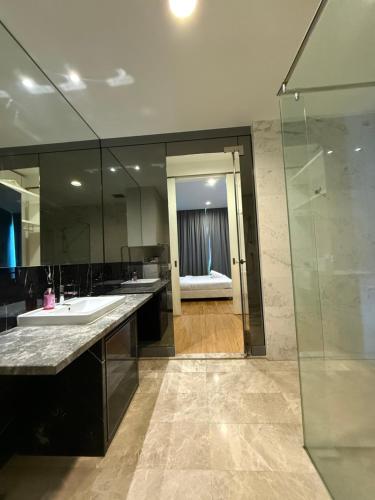 a bathroom with a sink and a glass shower at Platinum KLCC by Like Home KUALA LUMPUR in Kuala Lumpur