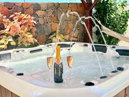 a hot tub with two glasses of champagne in it at Zolikaz in Grand-Baie