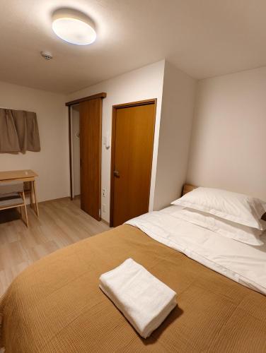 a bedroom with a bed with a towel on it at THE ONE kouennji in Tokyo