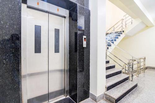 a hallway with a glass door and stairs at FabHotel Urban Classy in Bhubaneshwar
