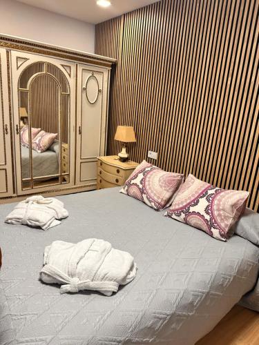 una camera con un grande letto e uno specchio di Loft con SPA exterior climatizado Villa IRI a Pineda de Mar