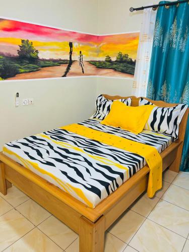 1 cama en una habitación con un cuadro en la pared en Résidence Yavanie, en Kribi