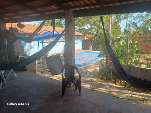 a porch with a hammock and a chair on a patio at Aconchego Santa Luzia in Pirenópolis