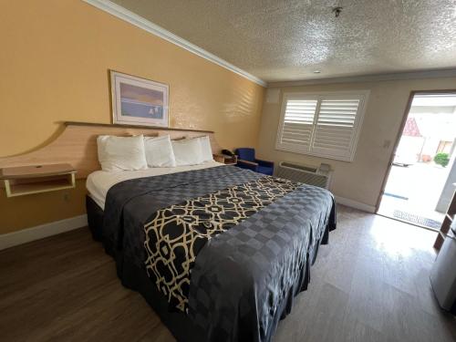 une chambre d'hôtel avec un lit et une fenêtre dans l'établissement Budget Inn Corcoran Near Tulare CA 43, à Corcoran