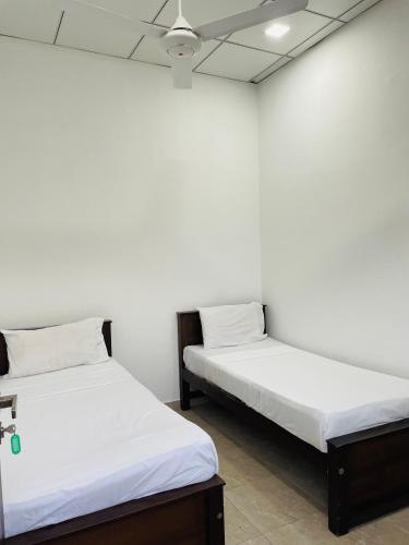 two beds sitting next to each other in a room at Sholay Villa in Galle
