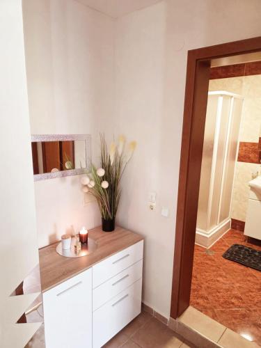 a bathroom with a counter with a vase of flowers at Summer Dream, Nesebar Fort Club, Sunny Beach in Sunny Beach