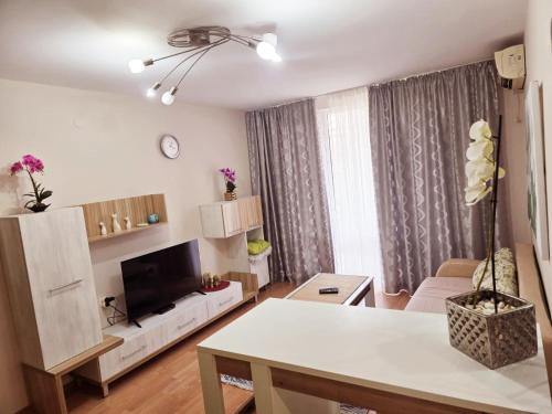 a living room with a table and a tv in it at Summer Dream, Nesebar Fort Club, Sunny Beach in Sunny Beach