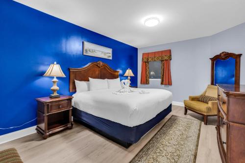 a blue bedroom with a bed and a chair at Hosteeva Beachfront Condo at Anderson Ocean Club in Myrtle Beach