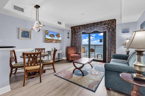 a living room with a couch and a table and chairs at Hosteeva Beachfront Condo at Anderson Ocean Club in Myrtle Beach