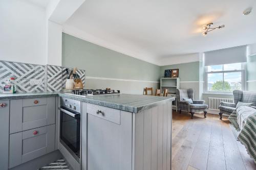 a kitchen with a stove top oven next to a living room at Perfectly Located, Central Bowness Flat With Free Parking and Lake Views in Windermere