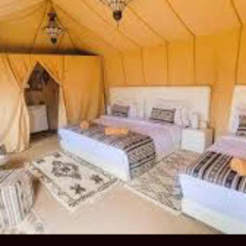 a room with two beds in a tent at Merzouga traditional Camp in Merzouga