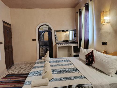 a bedroom with two beds and a fireplace in it at Maison Hassan Merzouga in Merzouga