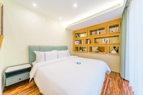 a bedroom with a large white bed and wooden floors at Argyle WAIFIDEN Baolidian Hotel -Free shuttle bus during Canton Fair in Guangzhou