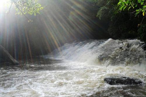 a stream of water with the sun shining on it at Prainha do Salto in Extrema