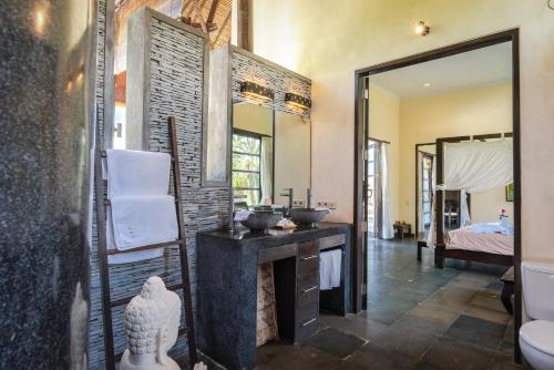 a bathroom with a sink and a mirror at Bali Amber Villa in Banjar