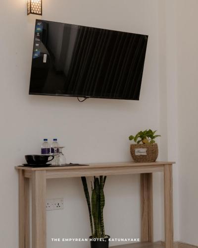 a flat screen tv on top of a wooden table at The Empyrean Airport Transit Hotel in Katunayake